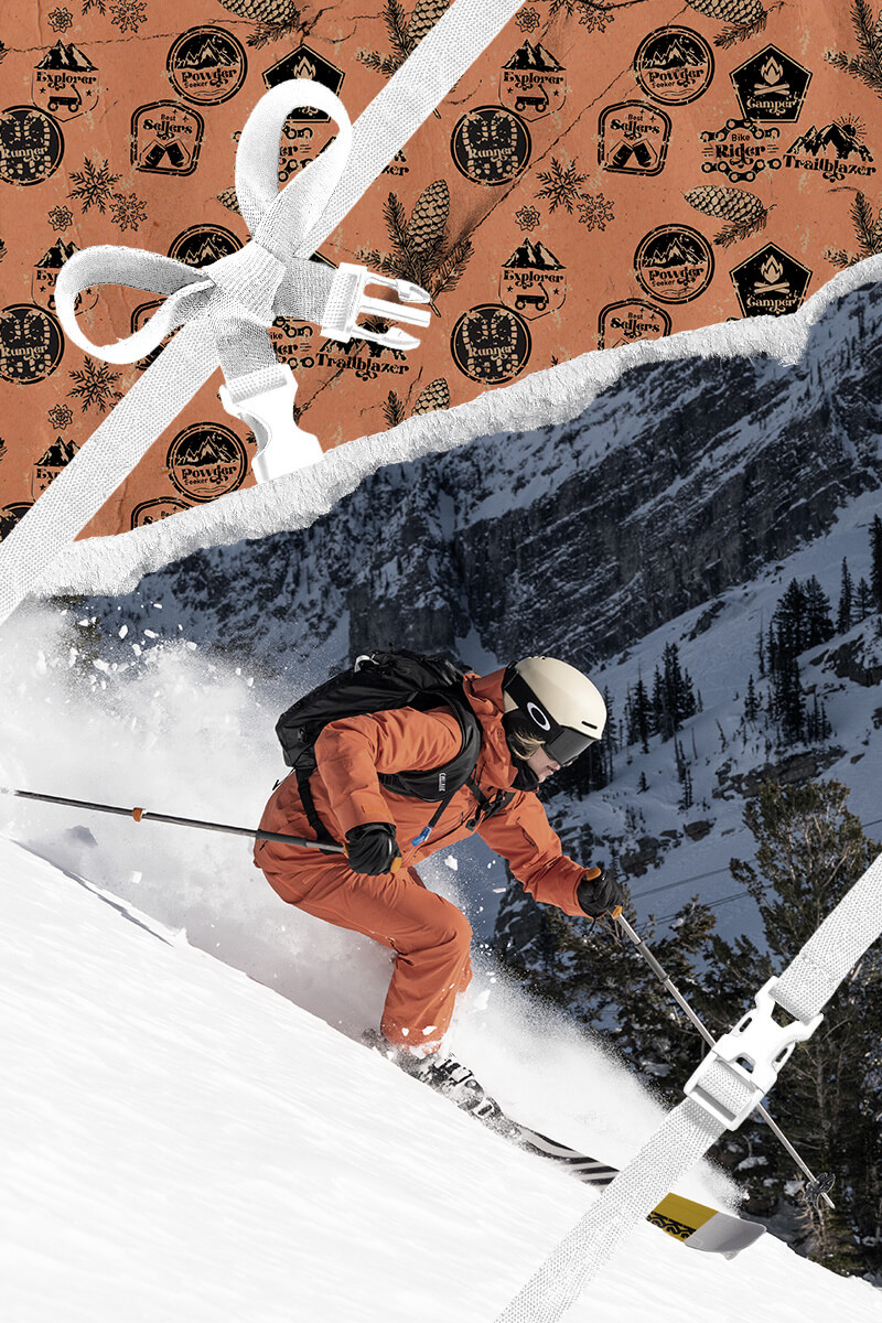 A skier going down the mountain with holiday themed wrapping paper framing the area around him. 